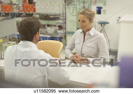 Stock Photography - Pharmacist consulting with patient. Fotosearch