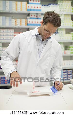 Stock Photography - Pharmacist counting pills at counter. Fotosearch