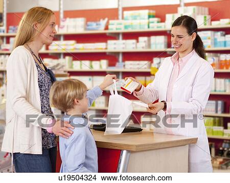 Picture - Pharmacist filling prescription in store. Fotosearch