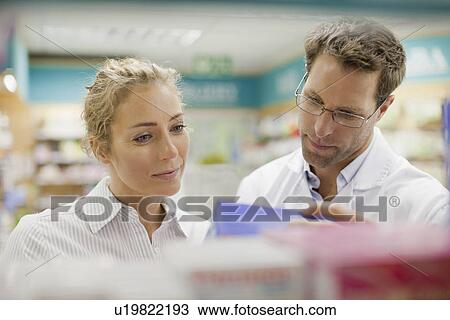 Pharmacist helping patient in store View Large Photo Image Stock Image - Pharmacist helping patient in store. Fotosearch