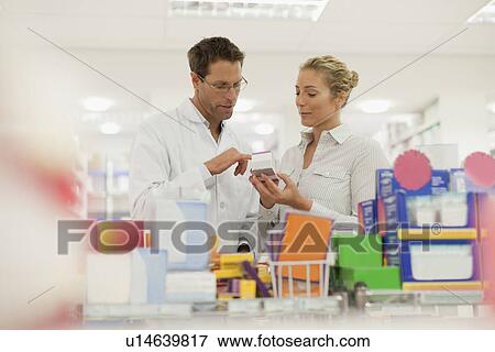 Stock Photo - Pharmacist helping patient in store. Fotosearch