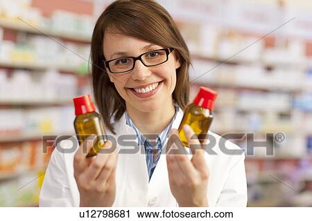 Pharmacist holding bottles of medication View Large Photo Image Stock Image - Pharmacist holding bottles of medication. Fotosearch