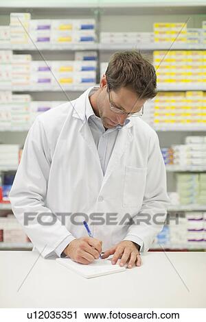 Pharmacist making notes at counter View Large Photo Image Stock Image - Pharmacist making notes at counter. Fotosearch