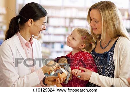 Pharmacist putting bandage on doll View Large Photo Image Picture - Pharmacist putting bandage on doll. Fotosearch