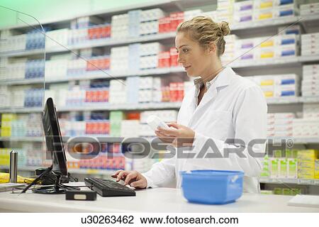 Pharmacist researching medication View Large Photo Image Stock Image - Pharmacist researching medication. Fotosearch