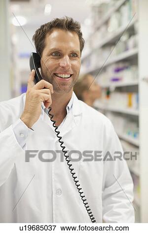 Pharmacist talking on phone View Large Photo Image Stock Photo - Pharmacist talking on phone. Fotosearch