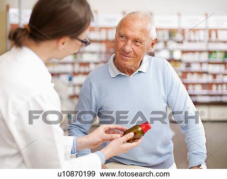 Stock Photo - Pharmacist talking to patient in store. Fotosearch