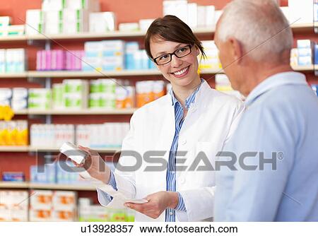 Pharmacist talking to patient in store View Large Photo Image Stock Photo - Pharmacist talking to patient in store. Fotosearch
