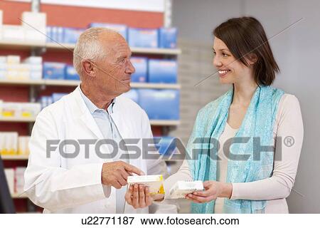 Stock Photo - Pharmacist talking to patient in store. Fotosearch