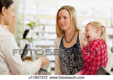 Pharmacist talking to patients in store View Large Photo Image Stock Image - Pharmacist talking to patients in store. Fotosearch