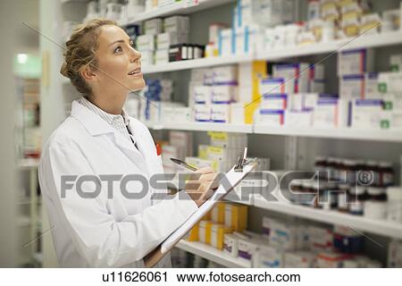 Pharmacist writing on clipboard View Large Photo Image Stock Image - Pharmacist writing on clipboard. Fotosearch