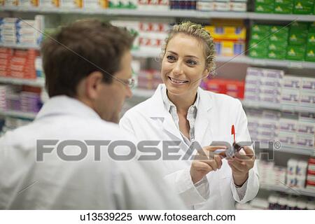 Pharmacists discussing medication View Large Photo Image Stock Photography - Pharmacists discussing medication. Fotosearch
