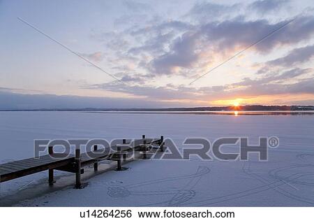 Stock Photograph - Pier jutting out into frozen lake. Fotosearch