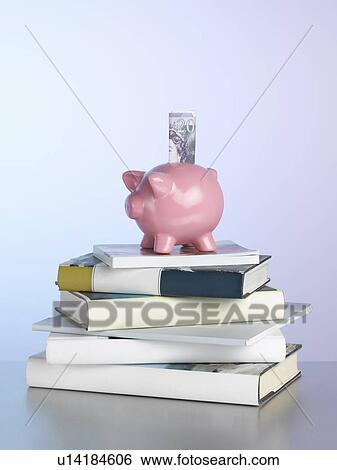 Piggy bank on stack of books View Large Photo Image Stock Photograph - Piggy bank on stack of books. Fotosearch