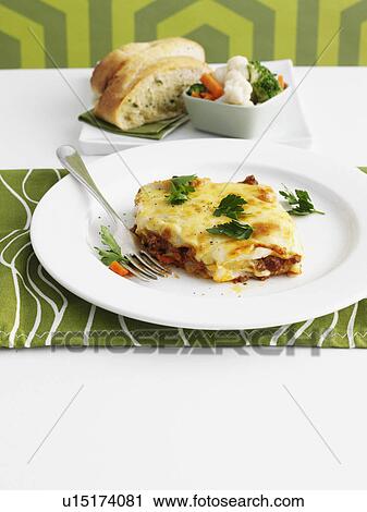 Plate of lasagna on table View Large Photo Image Stock Image - Plate of lasagna on table. Fotosearch