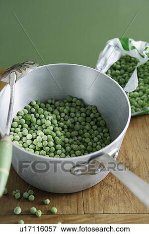 Stock Photo - Pot of frozen peas on wooden table. Fotosearch