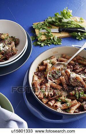 Stock Image - Pot of meat rigatoni with herbs. Fotosearch