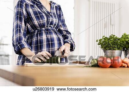 Pregnant woman chopping vegetables View Large Photo Image Stock Photo - Pregnant woman chopping vegetables. Fotosearch