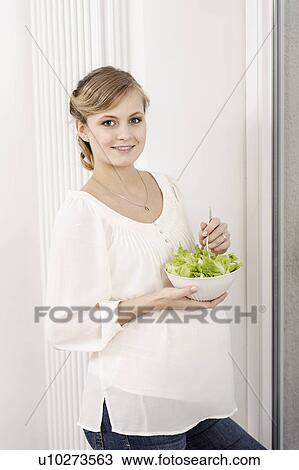 Stock Image - Pregnant woman eating salad. Fotosearch
