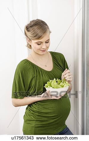 Stock Image - Pregnant woman eating salad. Fotosearch