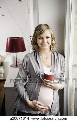 Pregnant woman having cup of coffee View Large Photo Image Picture - Pregnant woman having cup of coffee. Fotosearch