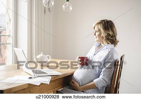 Pregnant woman having cup of coffee View Large Photo Image Stock Photo - Pregnant woman having cup of coffee. Fotosearch
