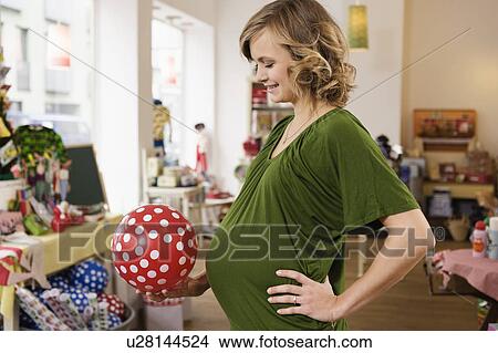 Pregnant woman holding rubber ball View Large Photo Image Picture - Pregnant woman holding rubber ball. Fotosearch