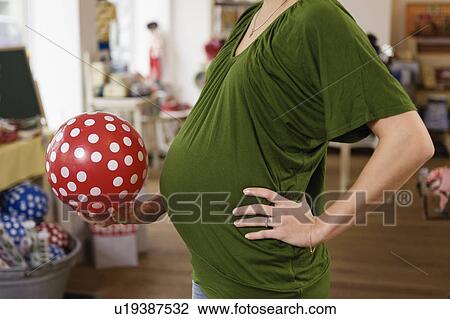 Pregnant woman holding rubber ball View Large Photo Image Stock Image - Pregnant woman holding rubber ball. Fotosearch
