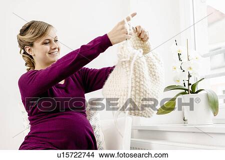 Pregnant woman knitting in living room View Large Photo Image Picture - Pregnant woman knitting in living room. Fotosearch