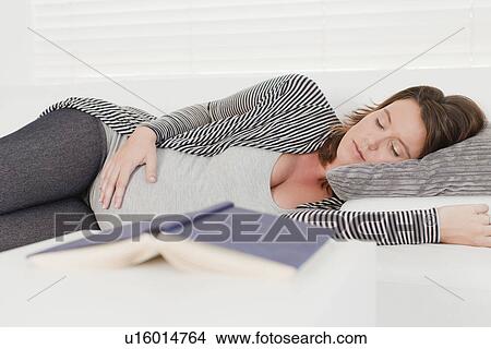Pregnant woman napping on sofa View Large Photo Image Picture - Pregnant woman napping on sofa. Fotosearch