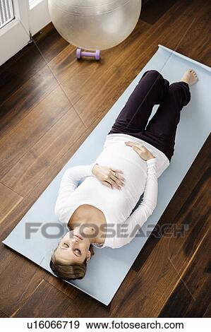 Pregnant woman practicing yoga on mat View Large Photo Image Stock Photo - Pregnant woman practicing yoga on mat. Fotosearch
