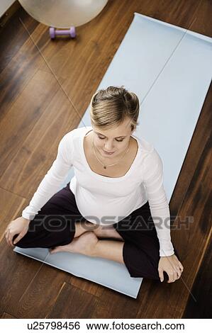 Pregnant woman practicing yoga on mat View Large Photo Image Stock Photograph - Pregnant woman practicing yoga on mat. Fotosearch
