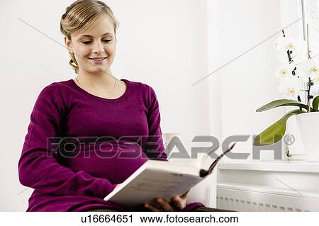 Pregnant woman reading in living room View Large Photo Image Stock Image - Pregnant woman reading in living room. Fotosearch