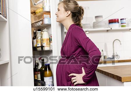 Pregnant woman searching fridge for food View Large Photo Image Stock Image - Pregnant woman searching fridge for food. Fotosearch