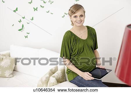 Pregnant woman using tablet computer View Large Photo Image Picture - Pregnant woman using tablet computer. Fotosearch