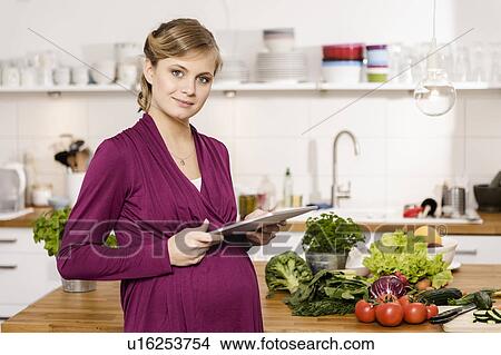 Picture - Pregnant woman using tablet computer. Fotosearch