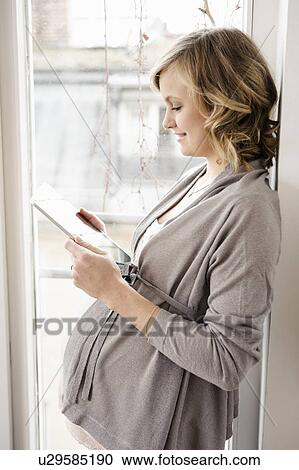 Pregnant woman using tablet computer View Large Photo Image Stock Image - Pregnant woman using tablet computer. Fotosearch