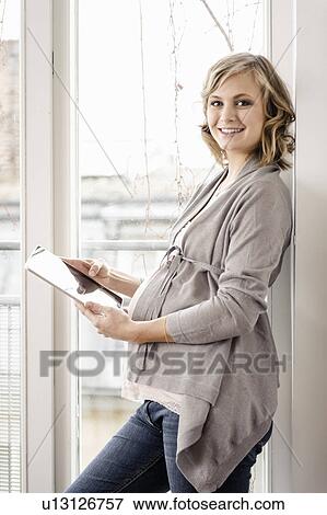 Pregnant woman using tablet computer View Large Photo Image Stock Photo - Pregnant woman using tablet computer. Fotosearch