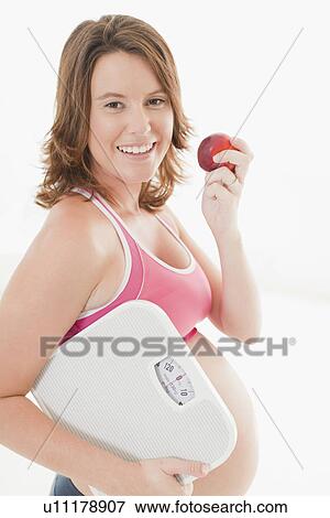 Pregnant woman with apple and scale View Large Photo Image Stock Photo - Pregnant woman with apple and scale. Fotosearch