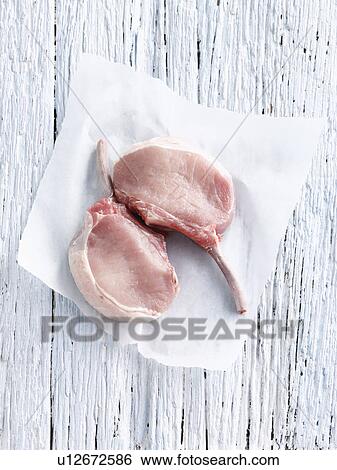Stock Photograph - Raw pork chop in butcher paper. Fotosearch
