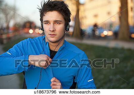 Stock Photograph - Runner listening to headphones outdoors . Fotosearch