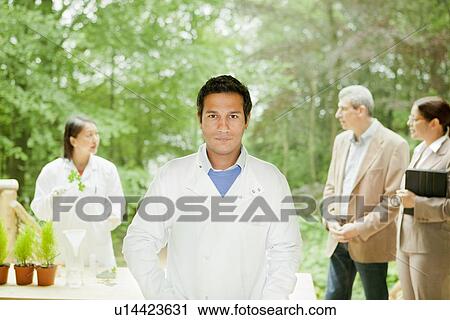 Stock Image - Scientist standing in meeting outdoors. Fotosearch