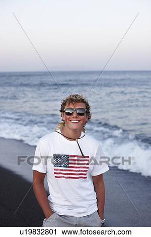 Smiling boy standing on beach View Large Photo Image Stock Image - Smiling boy standing on beach. Fotosearch