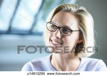 Stock Photography - Smiling businesswoman sitting in office. Fotosearch
