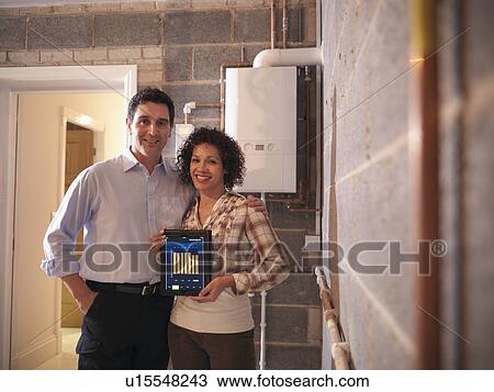 Smiling couple holding tablet computer View Large Photo Image Stock Image - Smiling couple holding tablet computer. Fotosearch