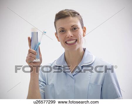 Smiling dentist holding toothpaste View Large Photo Image Stock Photo - Smiling dentist holding toothpaste. Fotosearch