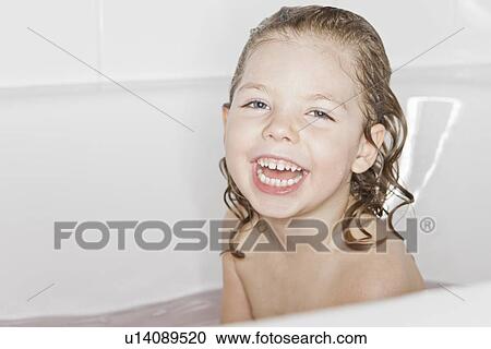 Stock Image - Smiling girl laughing in bath. Fotosearch