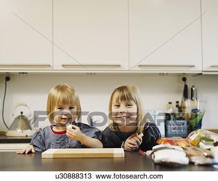 Smiling girls eating in kitchen View Large Photo Image Stock Image - Smiling girls eating in kitchen. Fotosearch