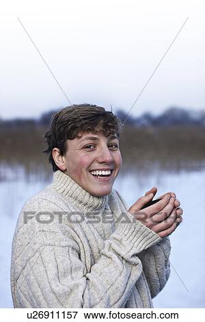 Stock Photo - Smiling man drinking coffee in snow. Fotosearch