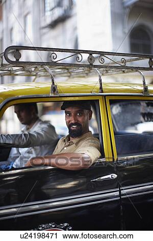 Stock Image - Smiling man riding in taxi cab. Fotosearch